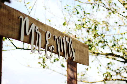 Mr and Mrs Signage in a brown arch in wedding venue during daytime photo under blue sky