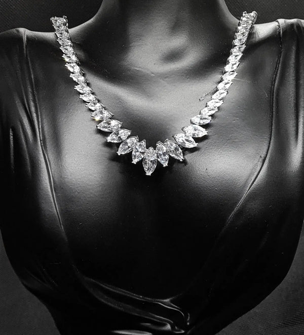 Sparkling cubic zirconia necklace with marquise cut stones on mannequin. The necklace is made up of a single row of marquise-cut cubic zirconia stones, which are sparkling and eye-catching. The necklace is perfect for a special occasion, such as a wedding or prom. It is also a great gift for a loved one.