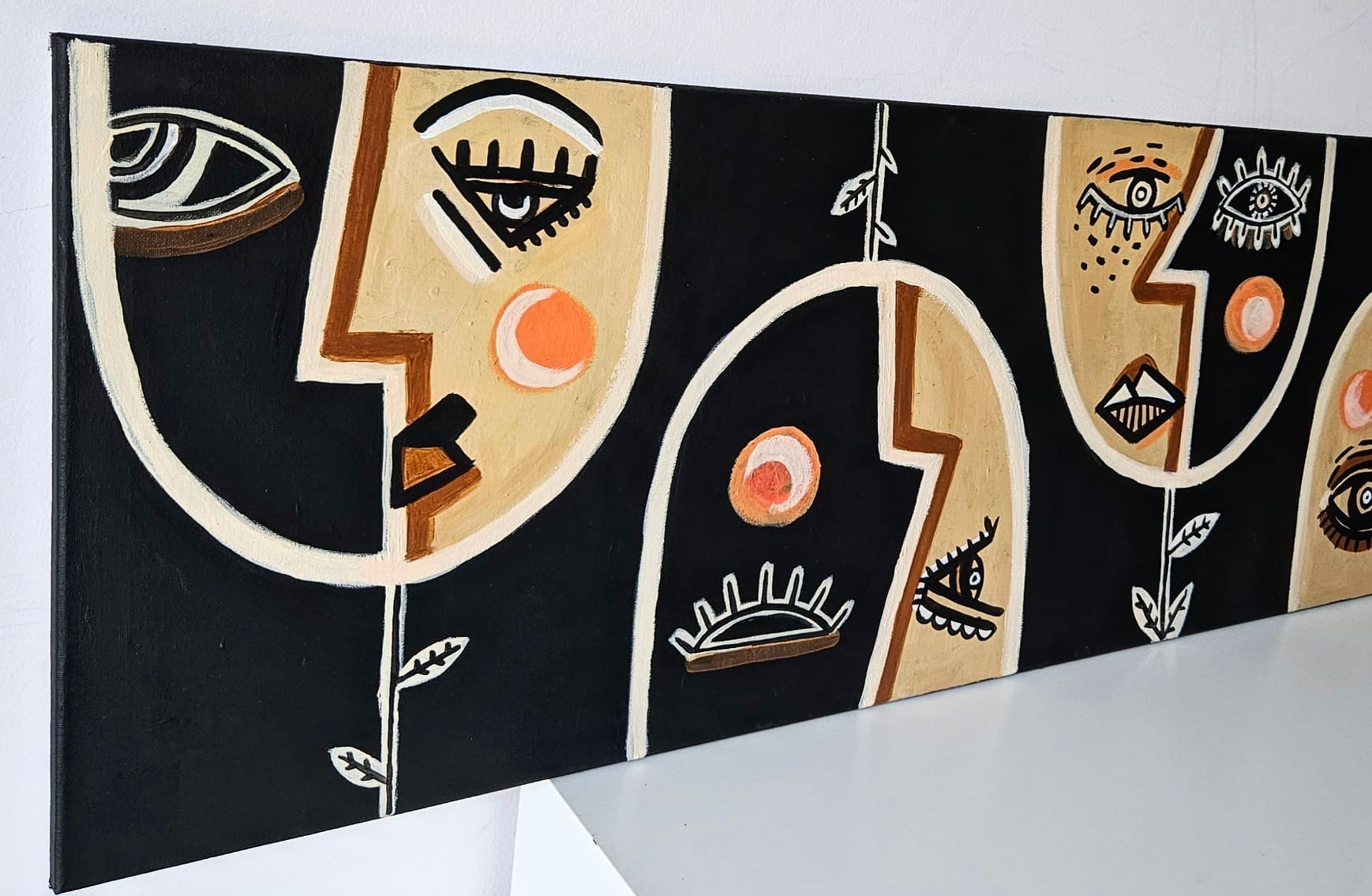 Botanical Harmony: Faces of Nature - Abstract painting with colorful shapes resembling faces on a black background.