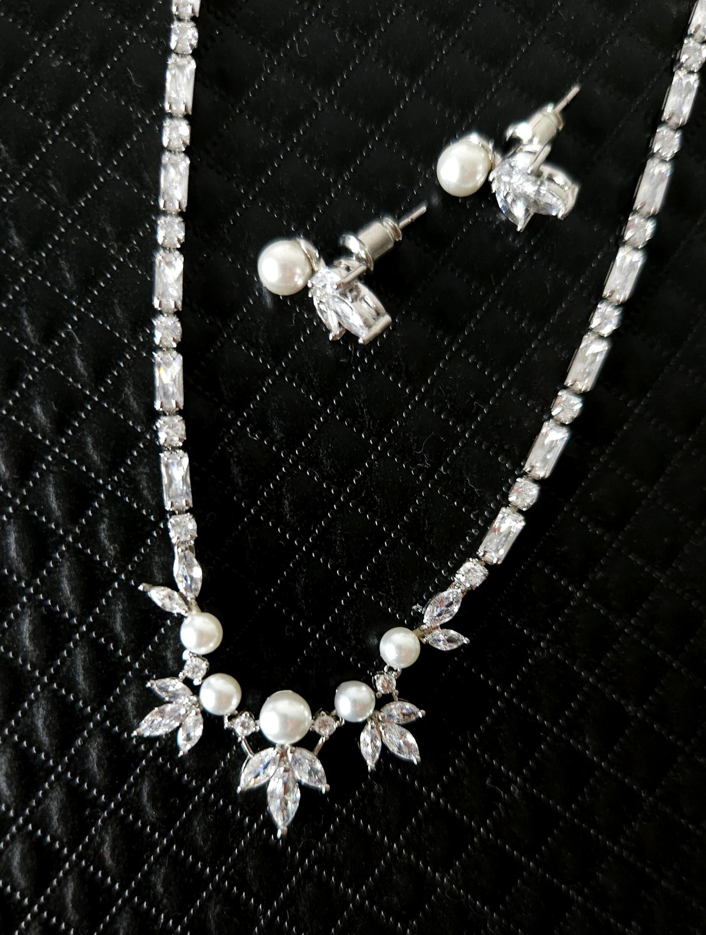 A stunning cubic zirconia and pearl jewelry set featuring a beautifully crafted necklace and matching earrings, perfect for weddings, parties, or any special occasion