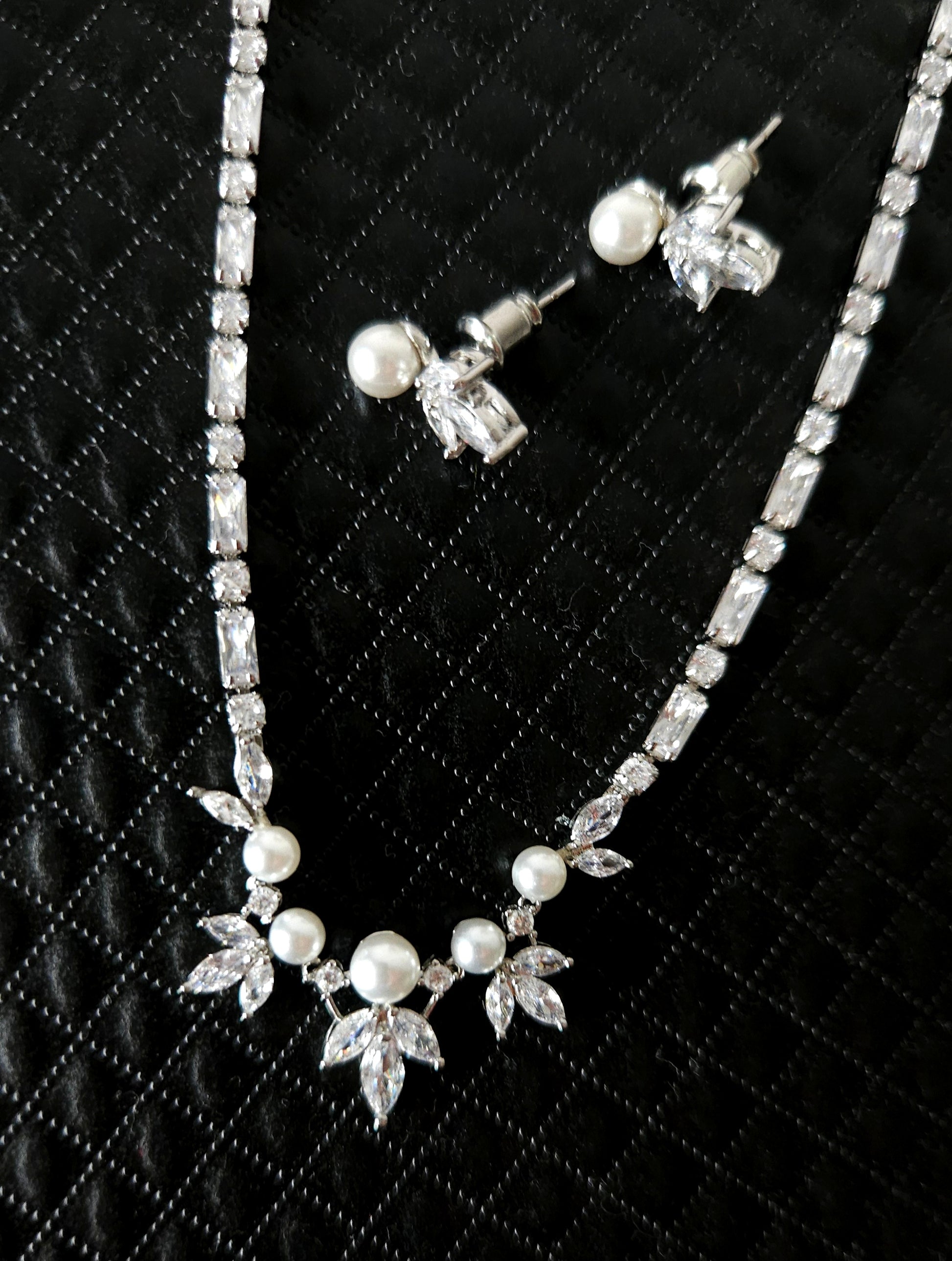 A stunning cubic zirconia and pearl jewelry set featuring a beautifully crafted necklace and matching earrings, perfect for weddings, parties, or any special occasion