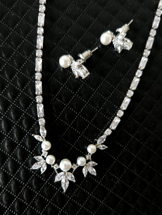 A stunning cubic zirconia and pearl jewelry set featuring a beautifully crafted necklace and matching earrings, perfect for weddings, parties, or any special occasion