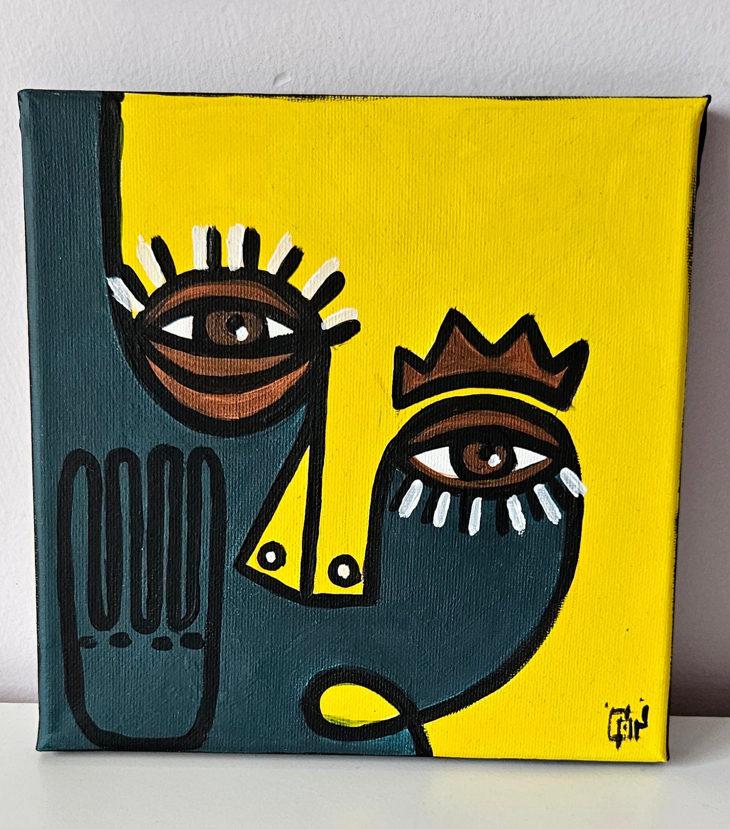 Three abstract paintings with stylized faces in different colors and shapes.