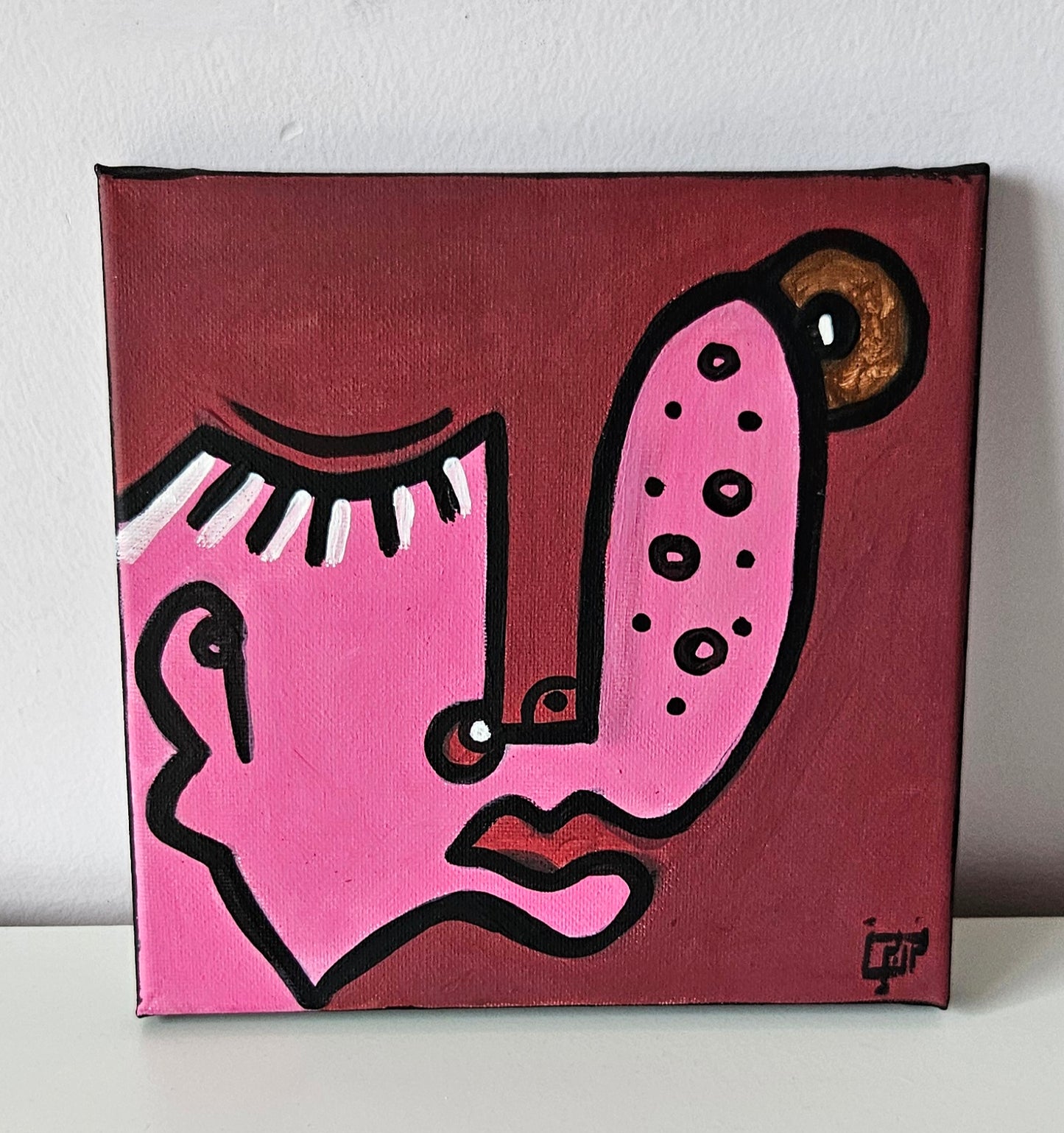 Three abstract paintings with stylized faces in different colors and shapes.