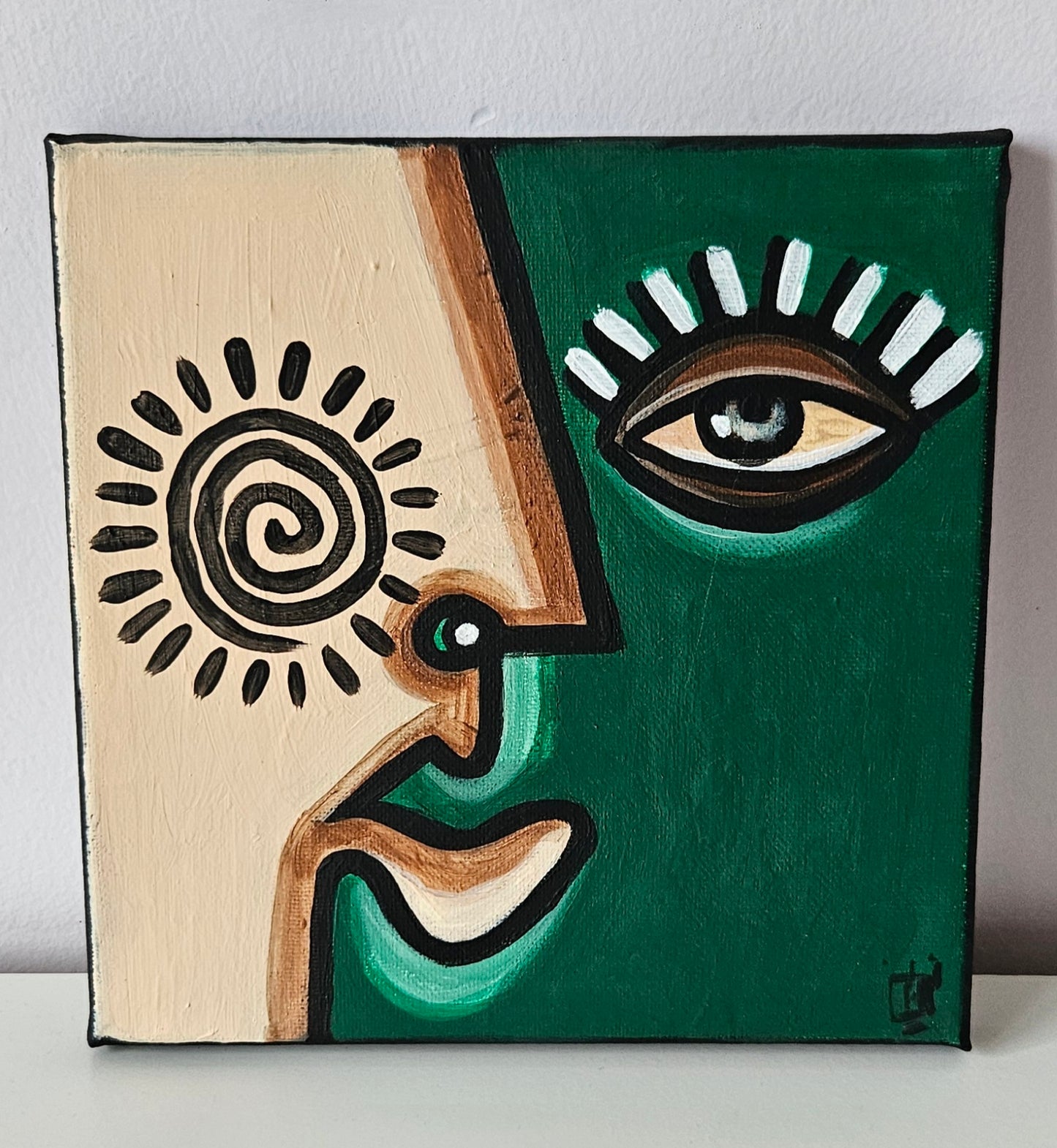 Three abstract paintings with stylized faces in different colors and shapes.