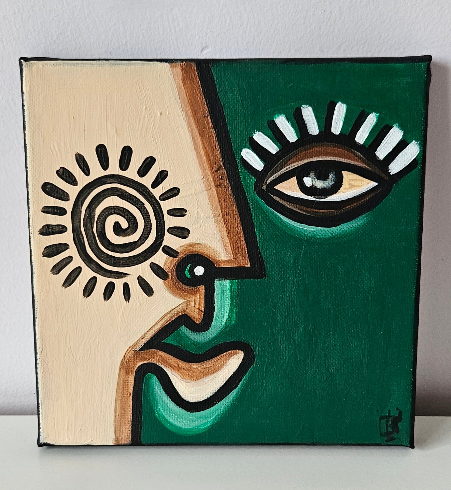 Three abstract paintings with stylized faces in different colors and shapes.
