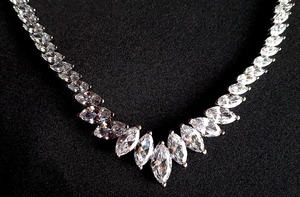 Close-up view of a diamond necklace sparkling with zirconia Diamonds displayed on a black table.