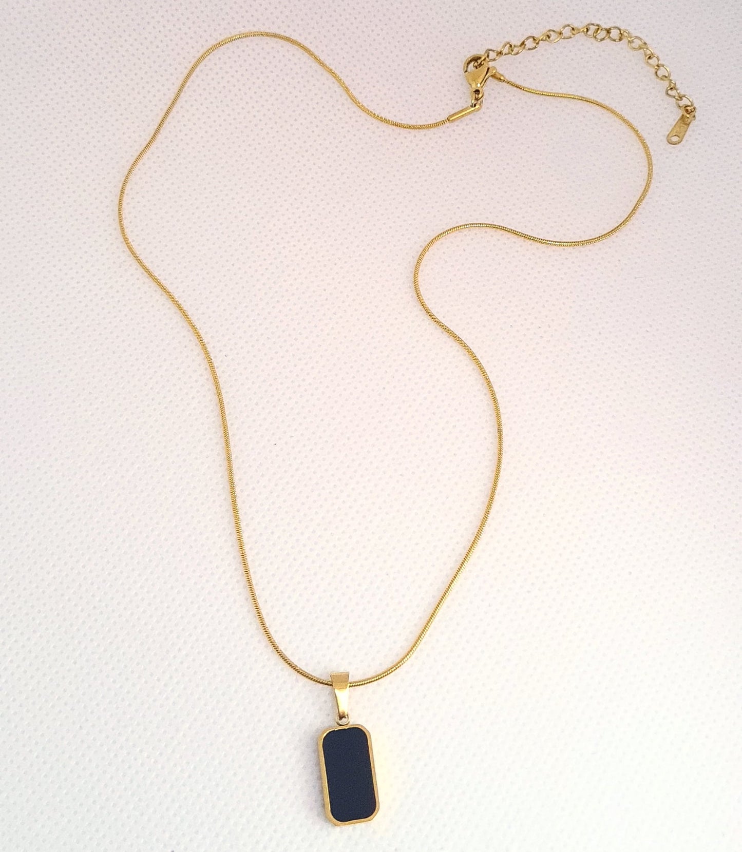 Charlotte Necklace featuring a sleek gold chain adorned with a double side black and white shell pendant