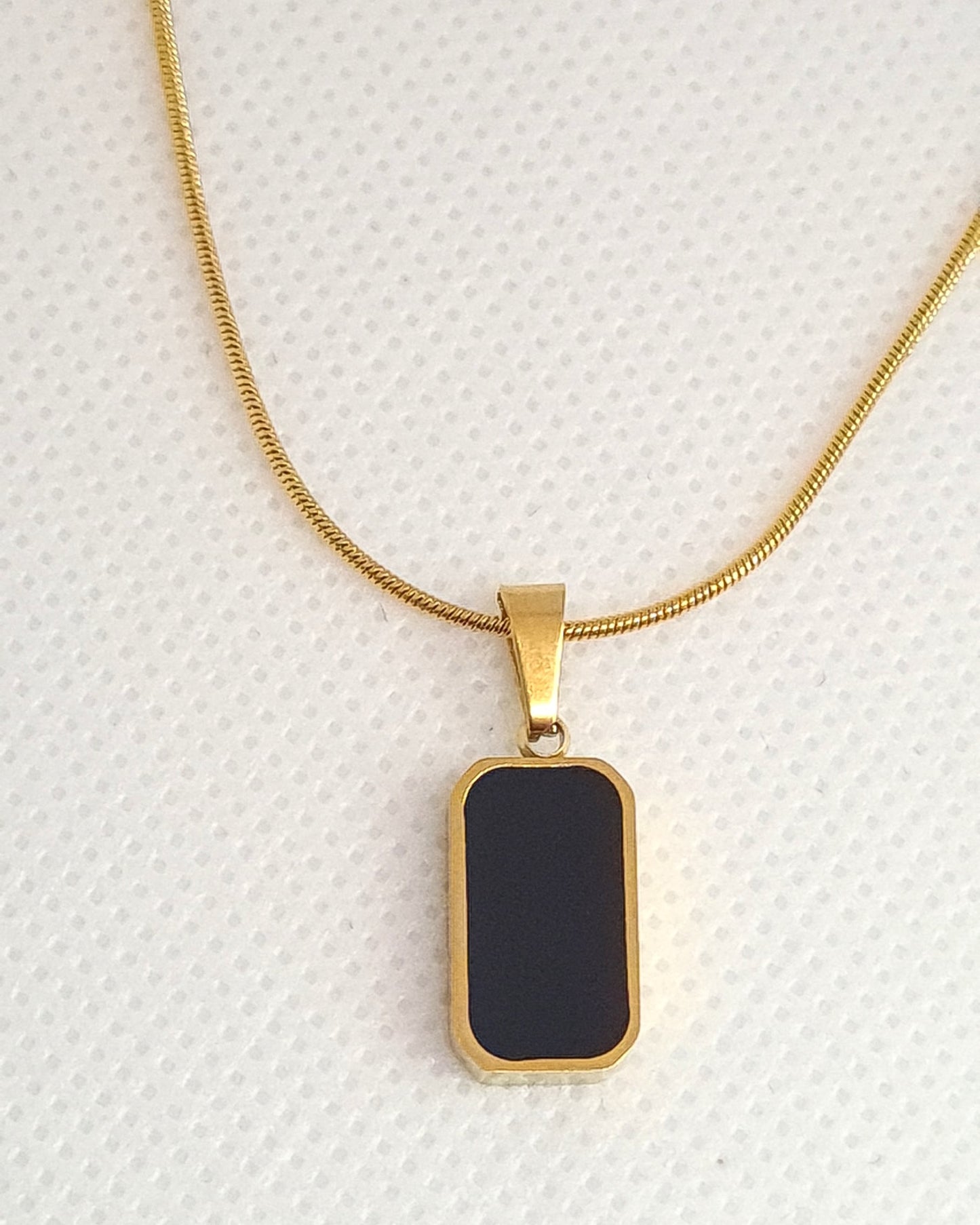 Charlotte Necklace featuring a sleek gold chain adorned with a double side black and white shell pendant