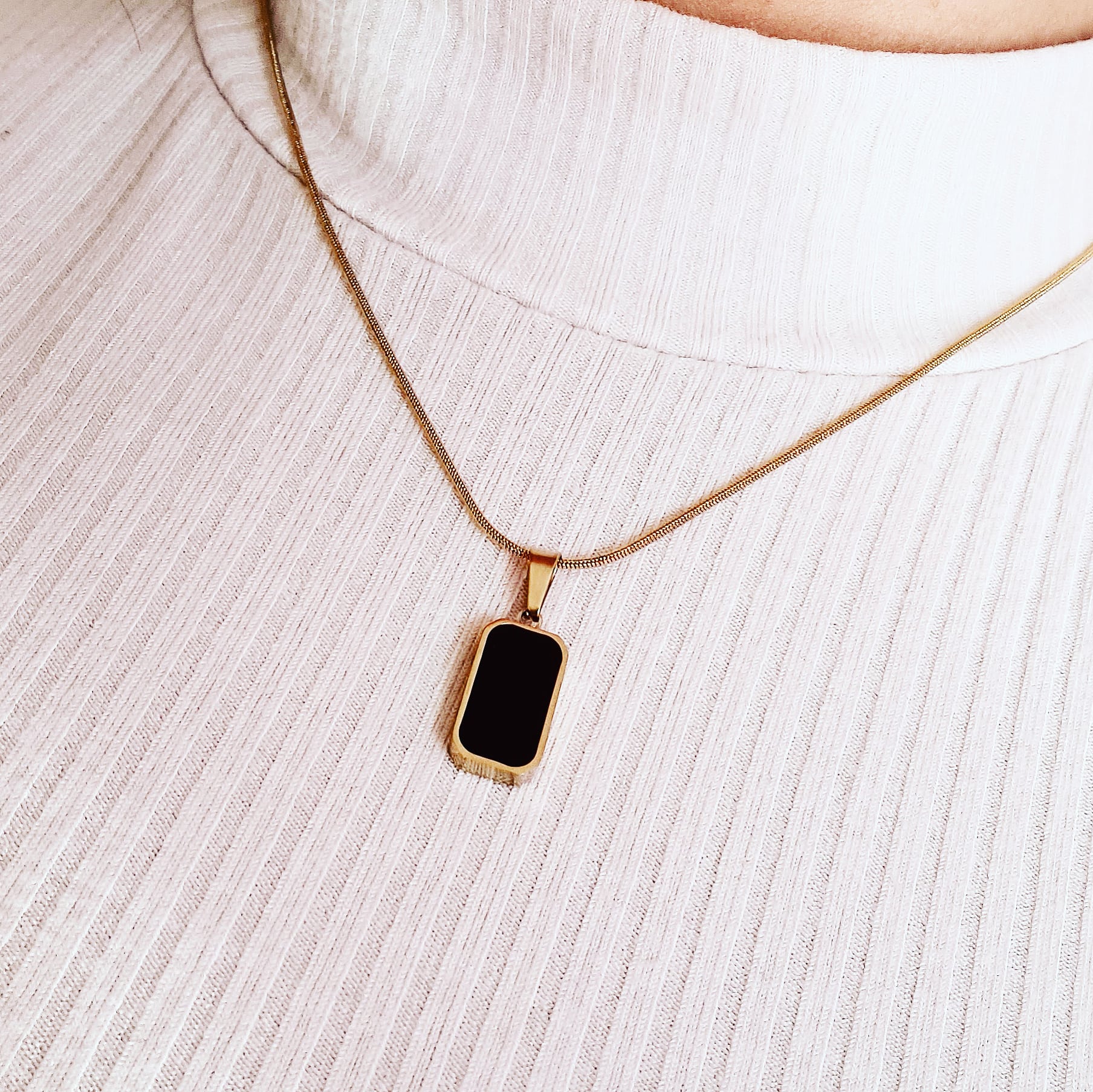 Charlotte Necklace featuring a sleek gold chain adorned with a double side black and white shell pendant