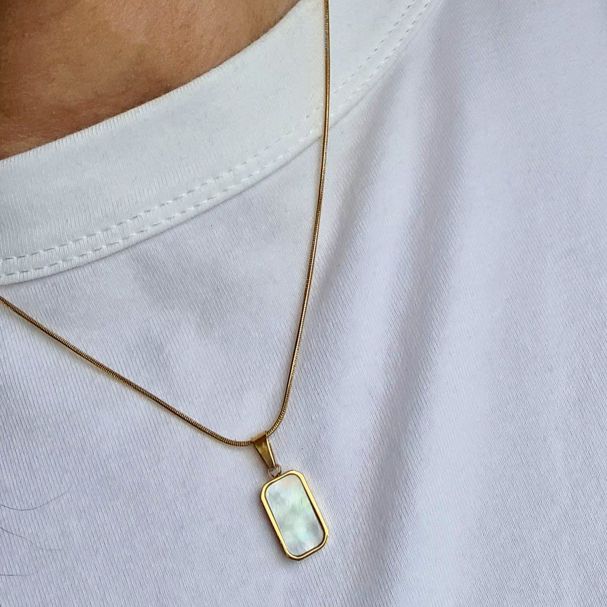 Charlotte Necklace featuring a sleek gold chain adorned with a double side black and white shell pendant