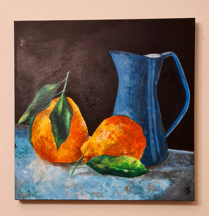 A painting of two orange pears and a blue pitcher on a table. The pears are ripe and full, with their smooth skin a deep orange color. The pitcher is a deep blue color, with a simple design. The background of the painting is a neutral gray color.