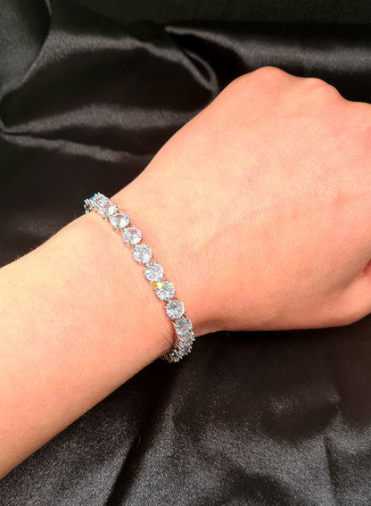 : A woman wearing a bracelet with diamonds on her wrist.