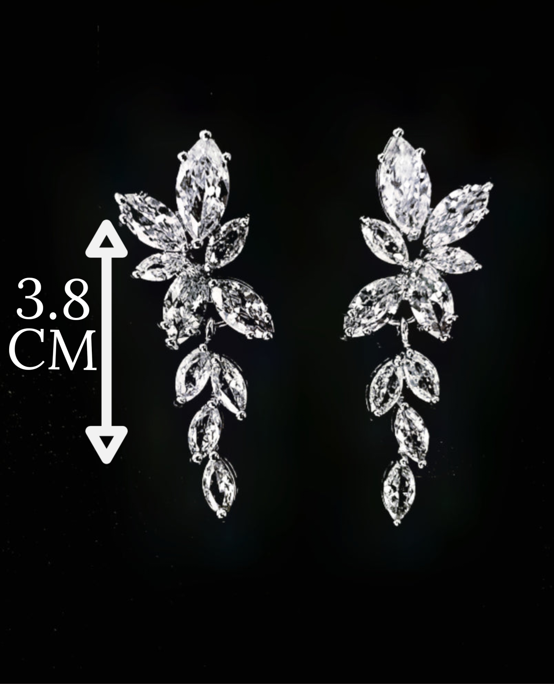 A close-up of a pair of silver earrings with white diamonds. The earrings are simple in design and the diamonds are sparkling. The earrings are very elegant and would be perfect for a special occasion. with measures.