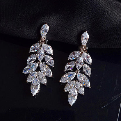 A pair of silver earrings with cubic zirconia. The earrings are simple in design and the cubic zirconia are sparkling. The earrings are a perfect accessory for a special occasion or a gift for a loved one.