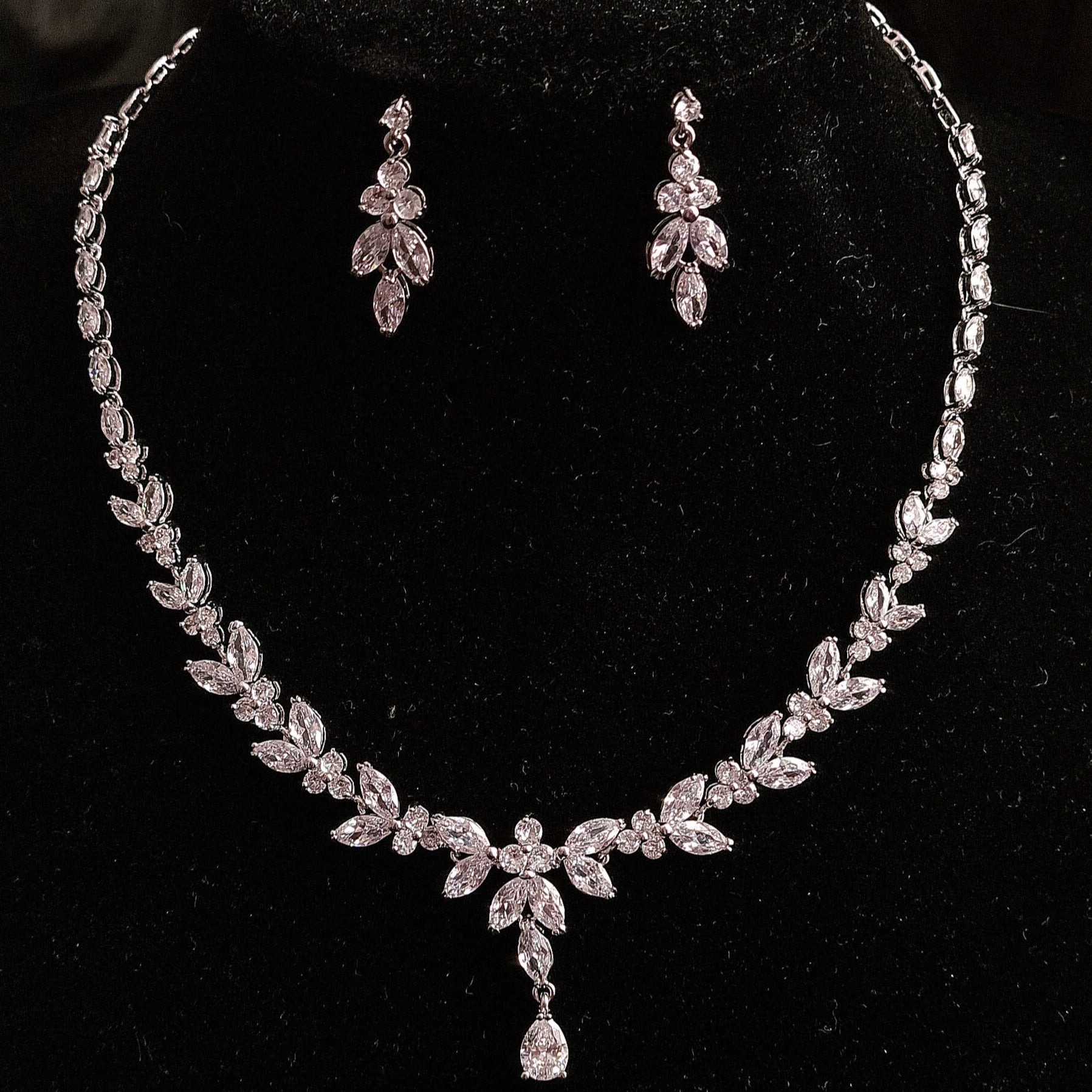 Elegant jewelry set featuring cubic zirconia earrings and necklace on display.