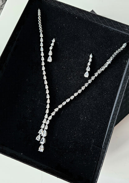 The Dilara Jewelry Set by La Pasión displayed on black box. This silver ensemble features a 44.45 cm botanical vine necklace with a 3.81 cm pear-cut drop and matching 3.18 cm x 0.64 cm marquise earrings, highlighting the brilliant craftsmanship and premium finish.