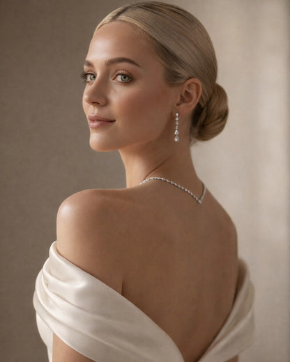 Woman wearing a white off-shoulder garment with a neutral background A premium back-view shot of a model in a silk gown, showcasing the 44.45 cm Dilara silver necklace drape.