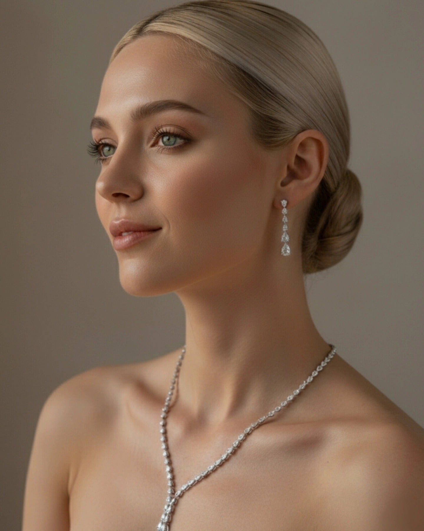 Editorial portrait of a model with an elegant blonde bun wearing the Dilara silver jewelry set by La Pasión. The 44.45 cm vine-style necklace features a 3.81 cm drop pendant, paired with 3.18 cm long marquise earrings for a sophisticated, high-fashion aesthetic.
