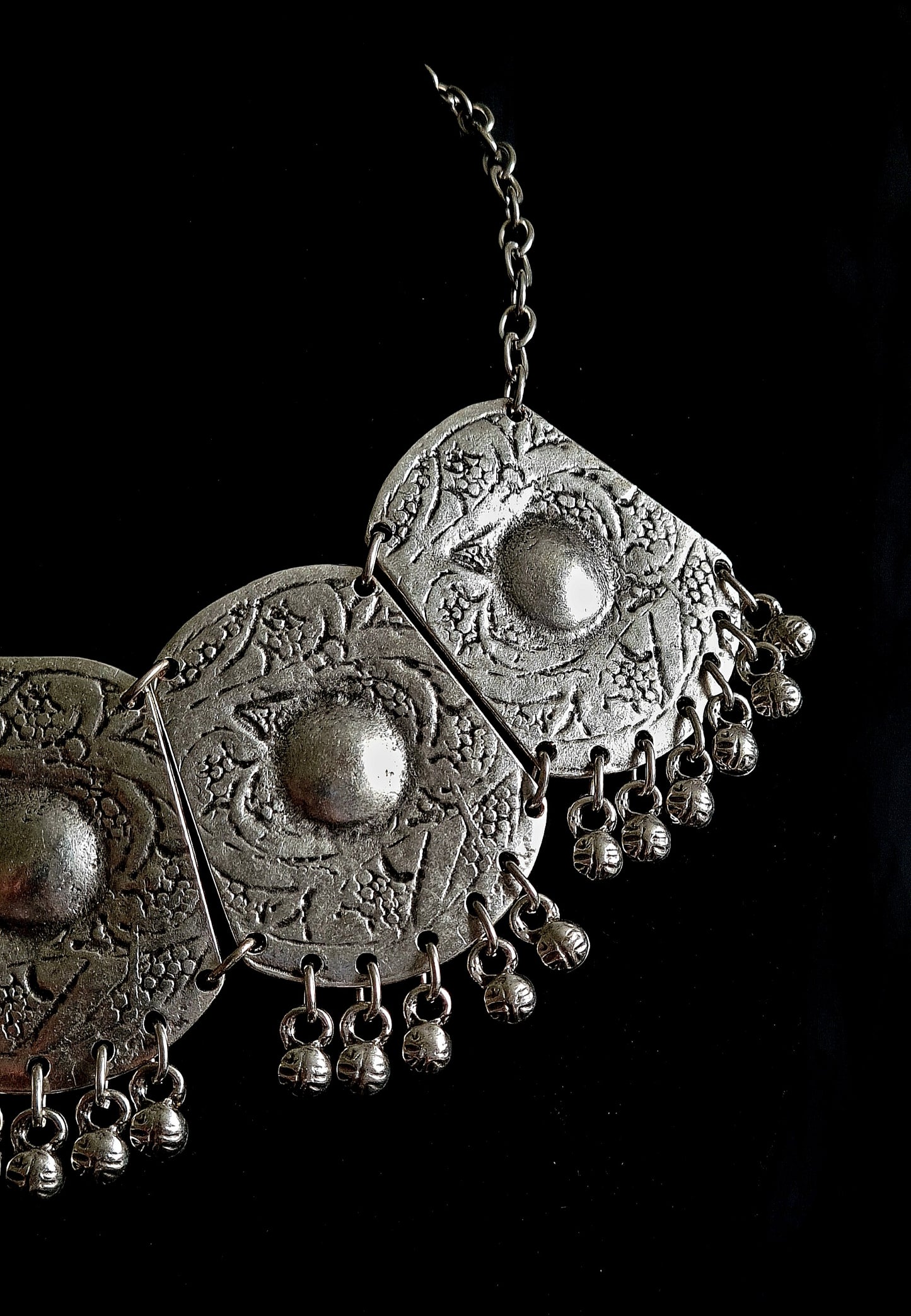 editorial mid-length portrait of a model wearing an ornate bohemian silver bib necklace over a white linen shirt, captured in a high-status, sophisticated brand style.