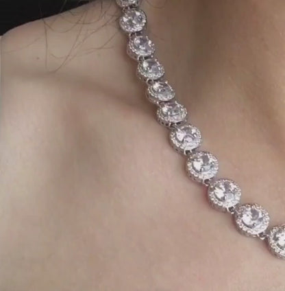 a close up view of a model wearing a silver necklace sparkling with Marquise Cut Cubic Zirconia.