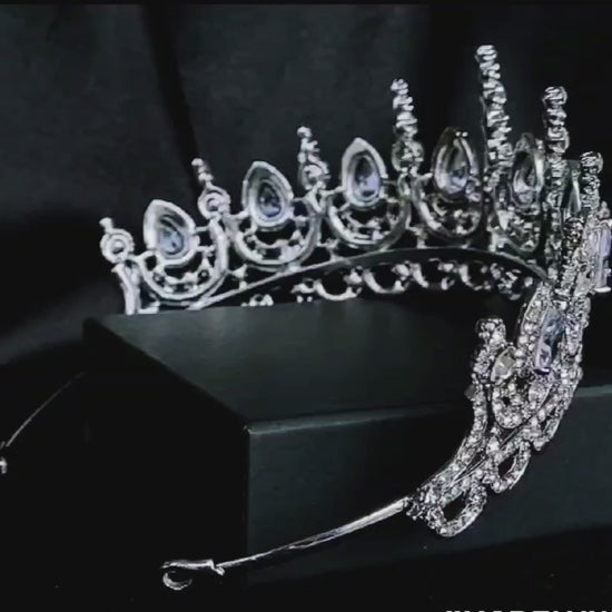 A close-up of a tiara made of cubic zirconia. The tiara is silver in color and has a cascading design. It is decorated with clear cubic zirconia stones that sparkle in the light.