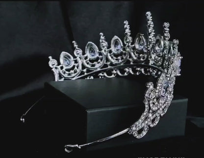 A close-up of a tiara made of cubic zirconia. The tiara is silver in color and has a cascading design. It is decorated with clear cubic zirconia stones that sparkle in the light.