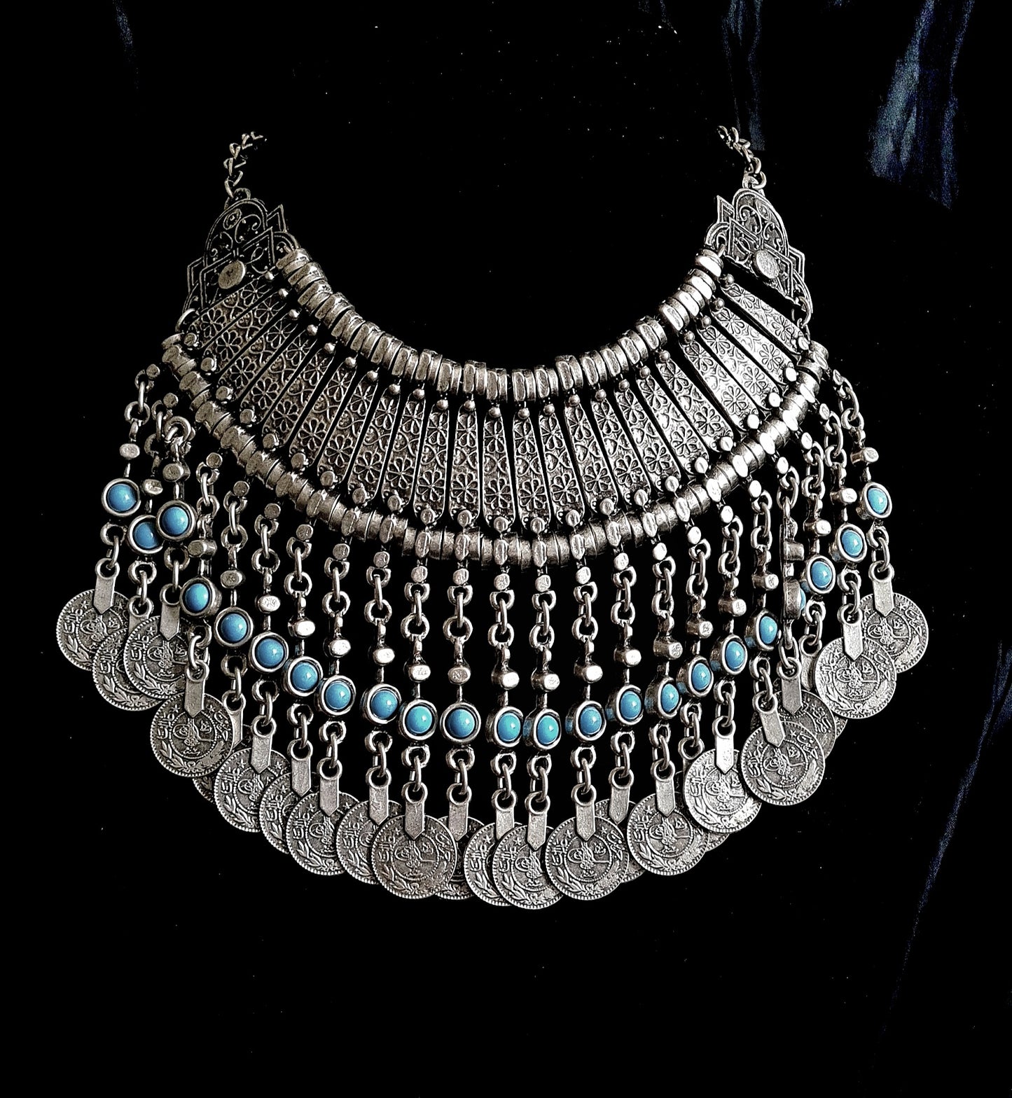 A premium silver-tone filigree statement necklace featuring turquoise stone accents and dangling Ottoman-style coins, reflecting a high-status heritage jewelry brand.
