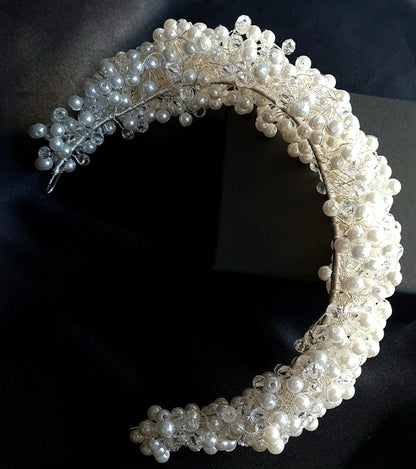 overview of A wedding hair accessory made of pearls and crystals. The headband has a delicate design with pearls and crystals.
