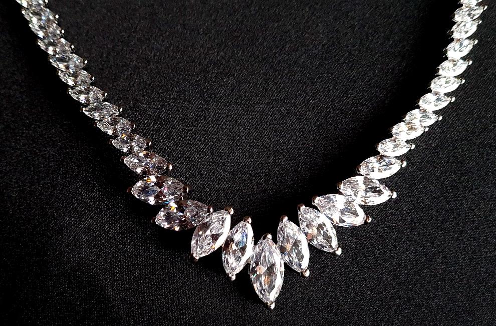 Close-up view of a diamond necklace sparkling with zirconia Diamonds displayed on a black table. 