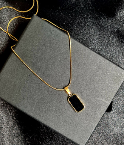 Charlotte Necklace featuring a sleek gold chain adorned with a double side black and white shell pendant