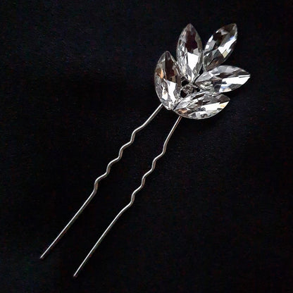 three hair pins with rhinestones on a black background. The hair pins are silver and have rhinestones of different sizes on them. The hair pins are in a triangular shape.