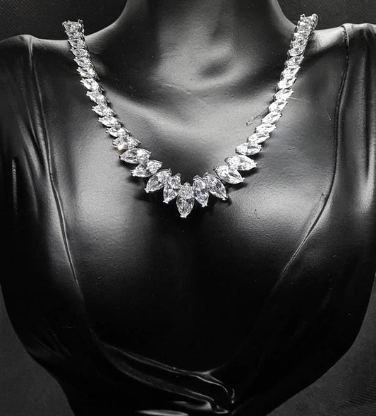 Sparkling cubic zirconia necklace with marquise cut stones on mannequin. The necklace is made up of a single row of marquise-cut cubic zirconia stones, which are sparkling and eye-catching. The necklace is perfect for a special occasion, such as a wedding or prom. It is also a great gift for a loved one.