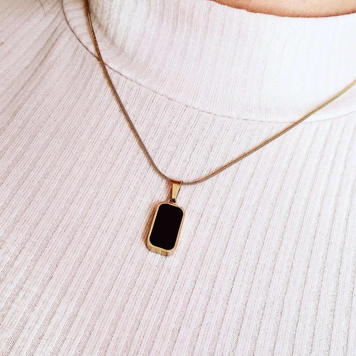 Charlotte Necklace featuring a sleek gold chain adorned with a double side black and white shell pendant