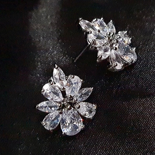 A pair of silver earrings with white diamonds. The earrings are simple in design and the diamonds are sparkling. These elegant earrings would be perfect for a special occasion and would make a great gift.